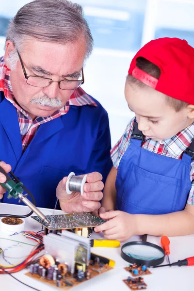 Grandfather showing PCB soldering to grandchild