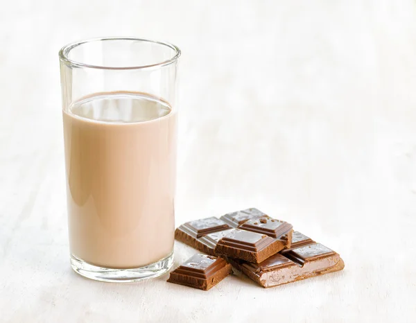 Chocolate milk and chocolate on white wooden table