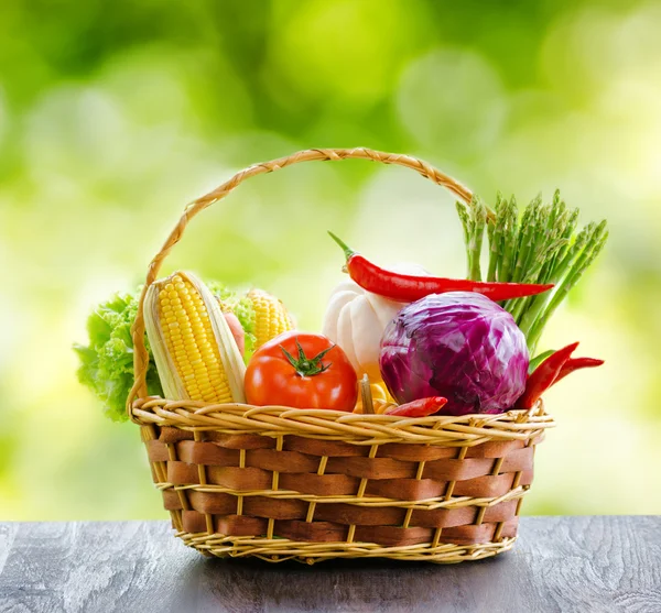 Fresh vegetables in the basket on wooden table