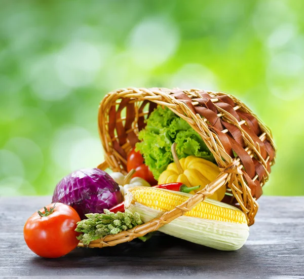 Fresh vegetables in the basket on wooden table