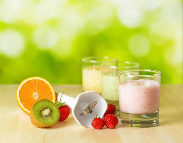 Fruit smoothie on wooden table on narural background