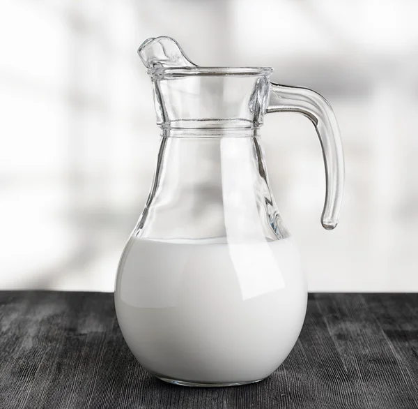 Jug of milk on the factory background. Half full pitcher