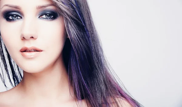 Portrait of beautiful young woman with long colored brown hair and bright make-up