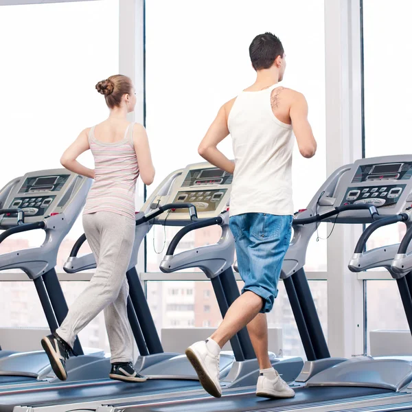 Woman and man at the gym exercising.