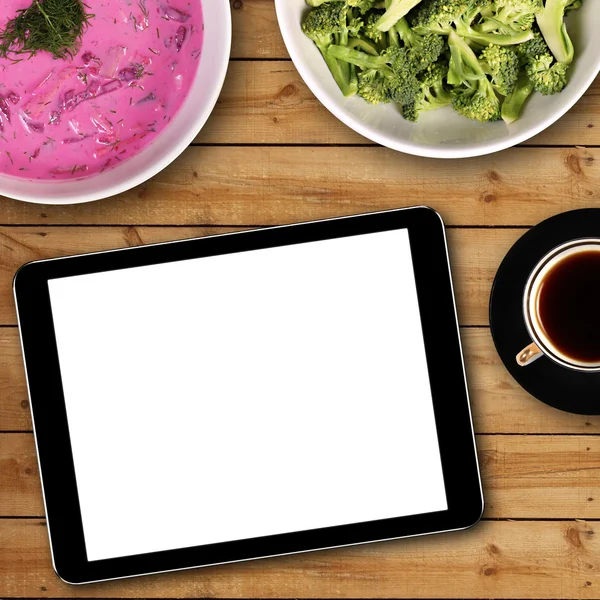 Digital tablet with white blank screen on dinner table