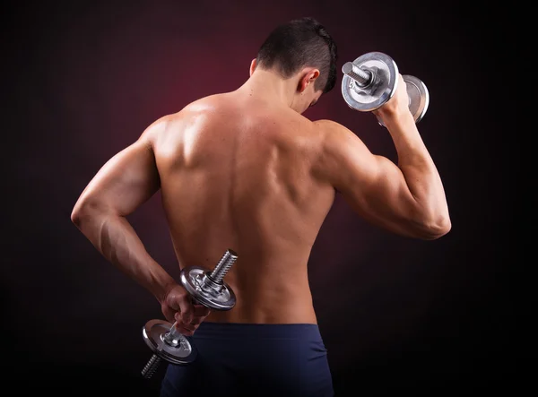 Powerful muscular man lifting weights on black background