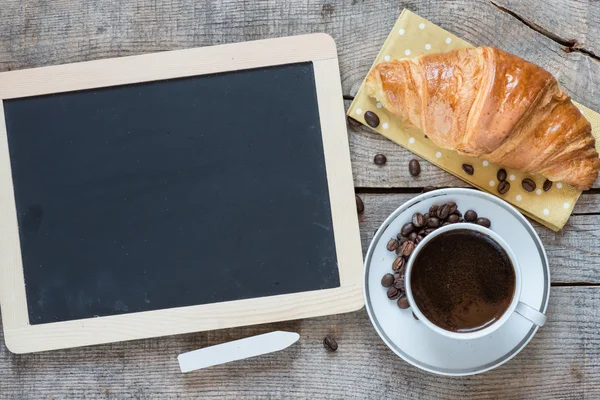 Blackboard with croissant and coffee