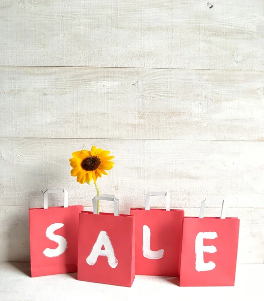 Red bargain sale shopping bags with sun flower