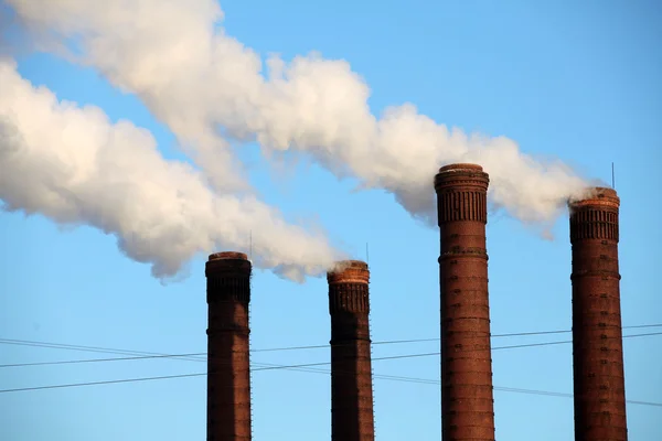 Industrial smoke from chimney on blue sky