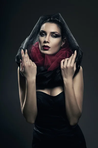 Mysterious woman in black hood in dark