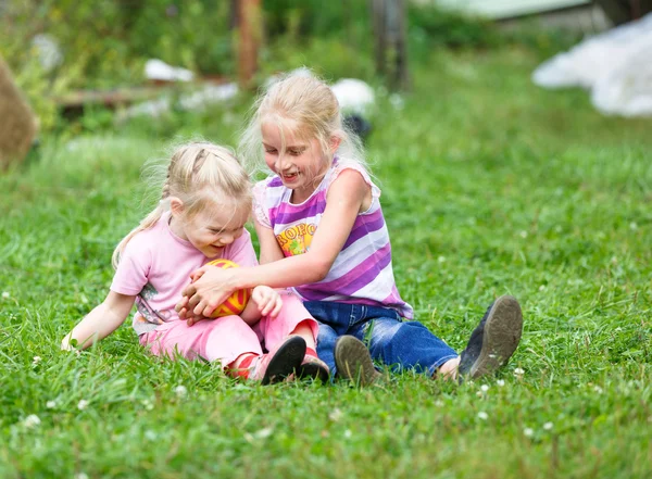 Two girls playing on the green grass