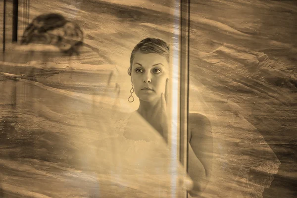 Retro sepia black and white photo, bride looks in the mirror in