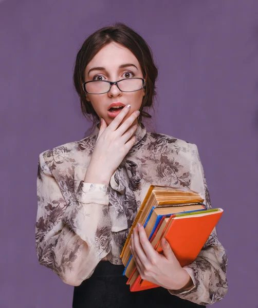 Girl woman brunette teacher in glasses with books surprised open