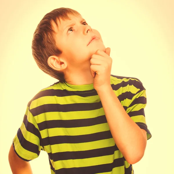 Boy child teen blonde in striped T-shirt scratching his head loo