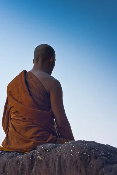 Monk meditating at the top of the mountain