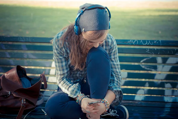Beautiful young blonde hipster woman listening music