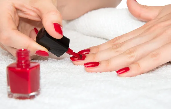 Woman hands doing manicure red nails
