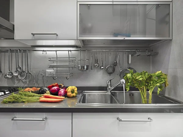 Detail of sink in the modern kitchen with vegetables