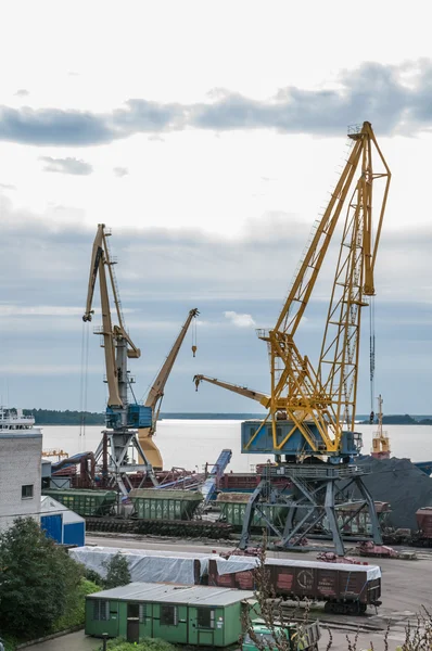 Two cranes loads cars