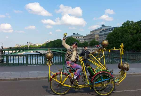 Unusual old man with a mustache on creative bike in Paris