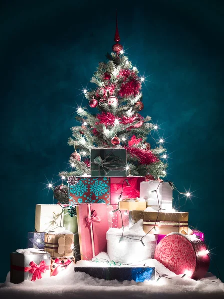 Brightly lit christmas tree with presents