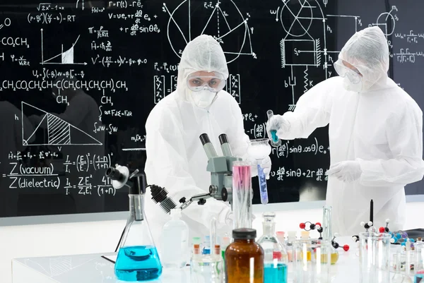 Scientists manipulating lab tools