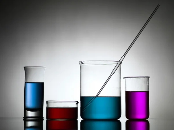 Beakers with dropper and colored liquid substances