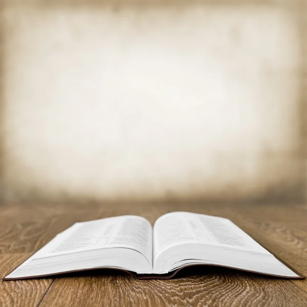 Open book on wood table over grunge background