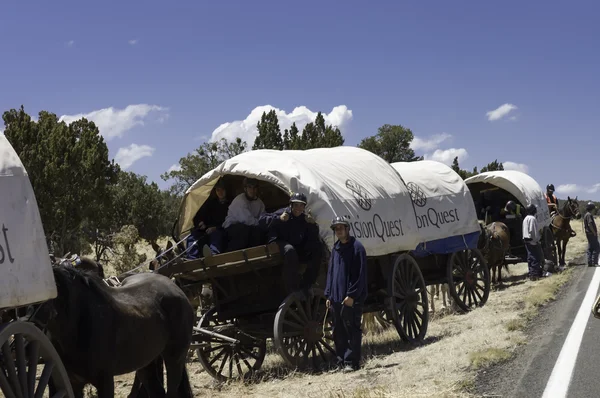 Teenagers traveling on covered wagons