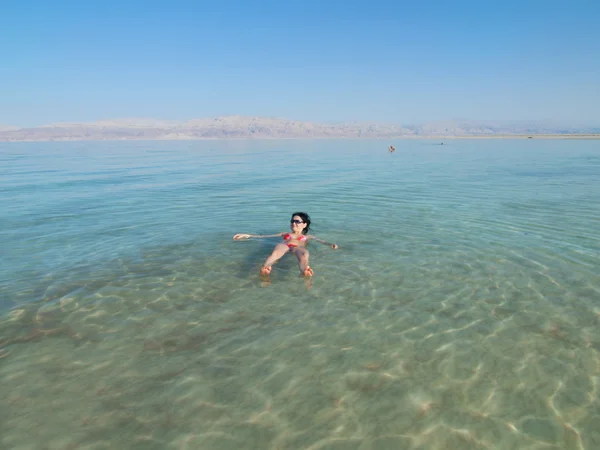 Woman swimming in salty water of a Dead Sea
