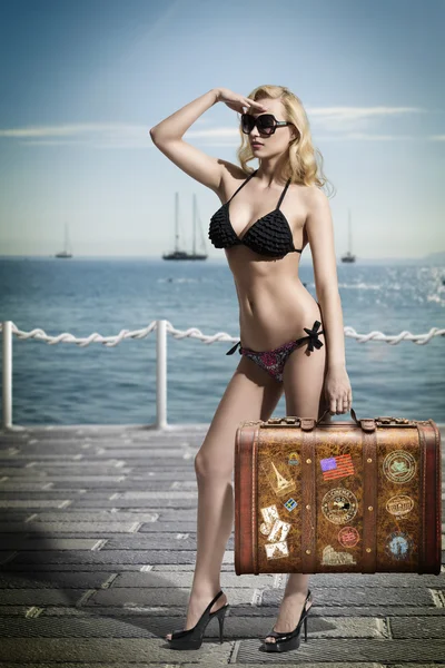 Sexy blonde tourist with vintage bag