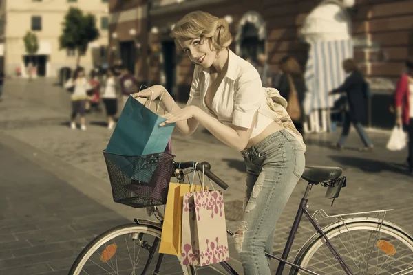 Smiling shopping girl on bicycle vintage color