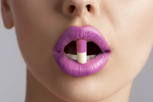 Sexy female mouth with pill