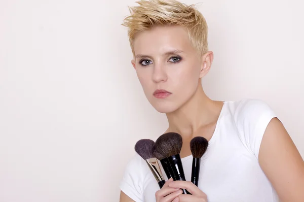 Make-up artist holding brushes