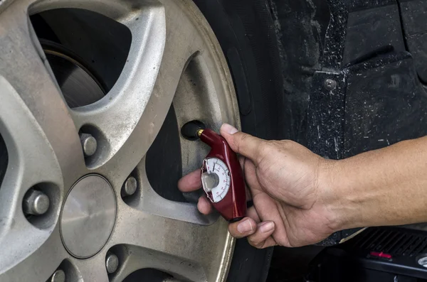 Checking tires with a hand held tire pressure gauge