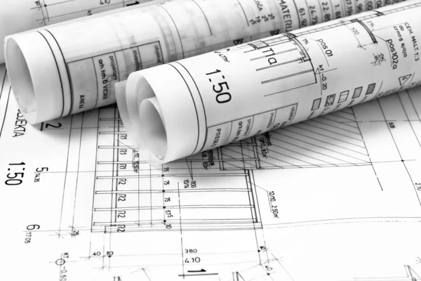 Heap of architect design and project drawings on table background