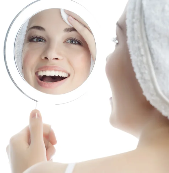 Woman is cleaning her face by cotton disc