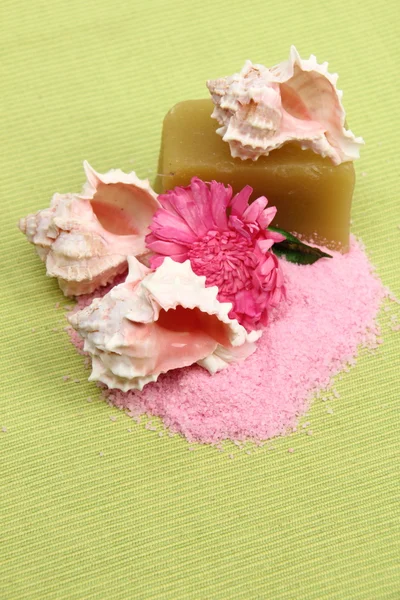 Decoration of sea salt, spa soap, beautiful sea shells and pink flower