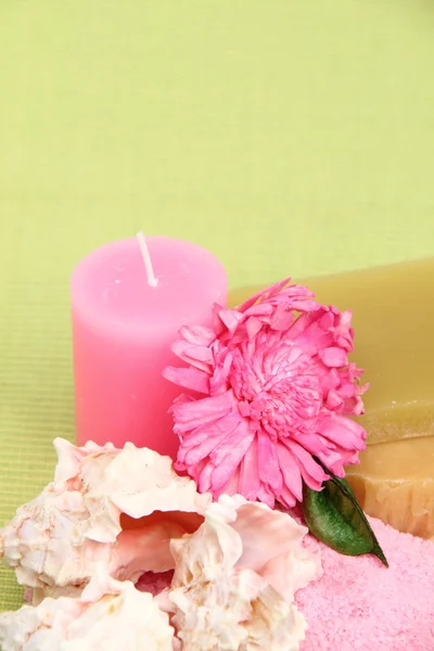 Decoration of sea salt, handmade soap, pink candle and flower