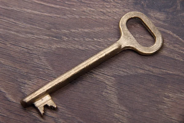 Antique key isolated isolated on dark wooden background