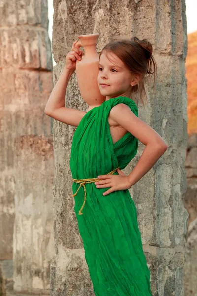 Charming girl in the emerald dress holding ancient amphora