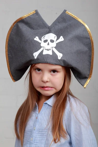 Terrible pirate girl in shirt and hat on a gray background