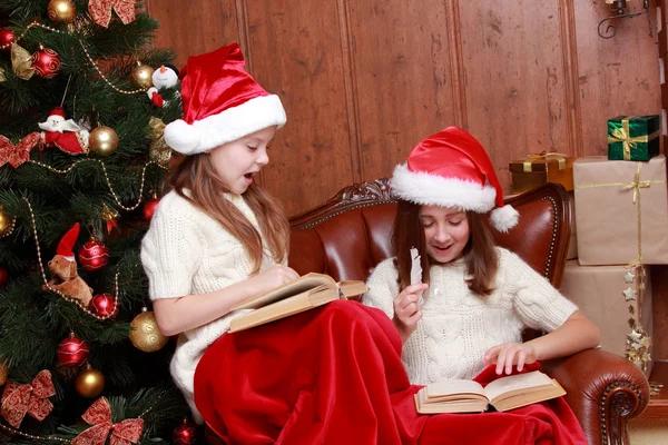 Girls wearing Santa hats holding books