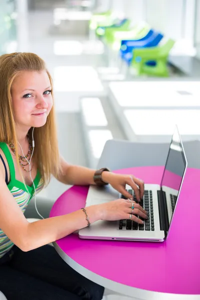 Pretty female college student working on her laptop computer