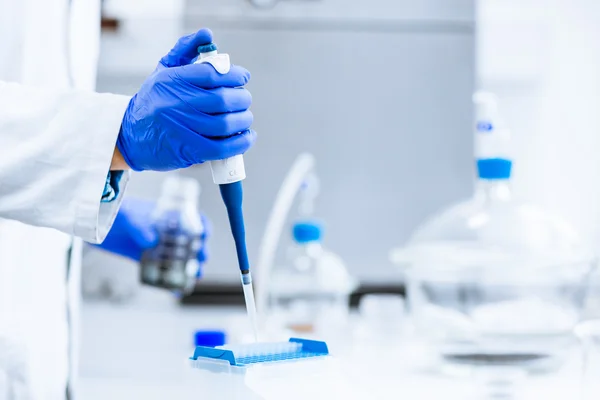 Hands of a researcher carrying out scientific research experimen