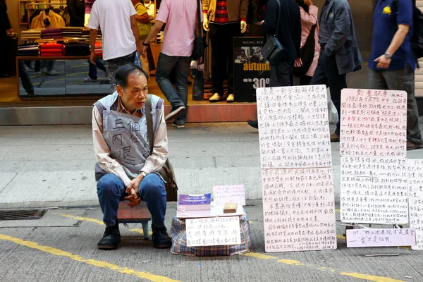 An old man sells books in Hong Kong