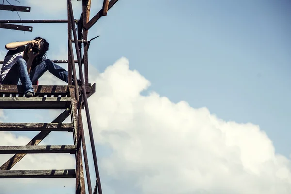 Girl the photographer sits an old ladder