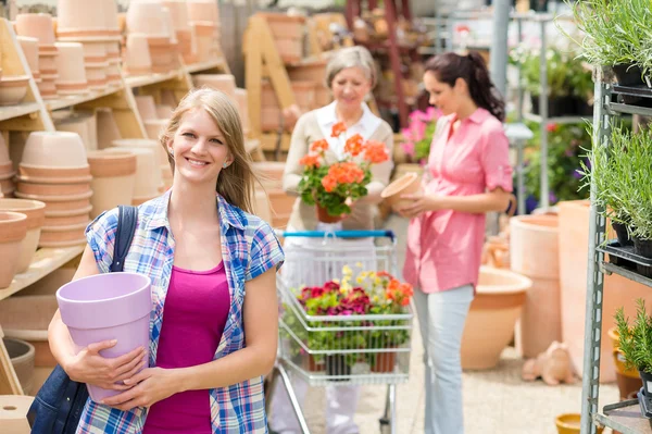 Woman holding purple pot in garden center