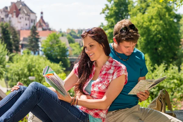 Young happy couple reading map city guide