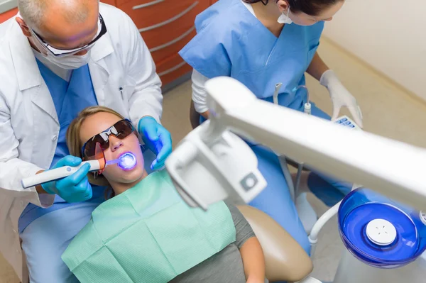 Dentist use UV lamp female patient